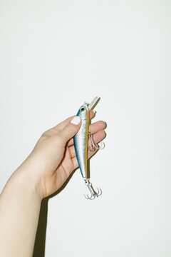 Hand holding fishing equipment lure with hard direct flashlight
