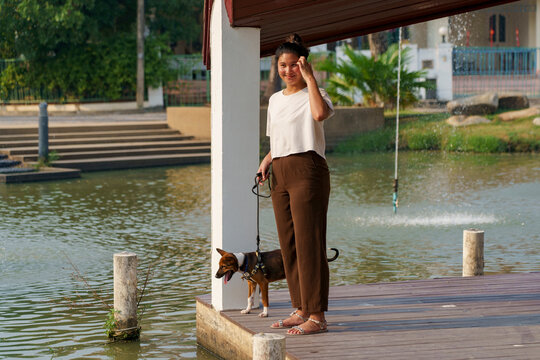 Young woman enjoys time with a puppy at sunset