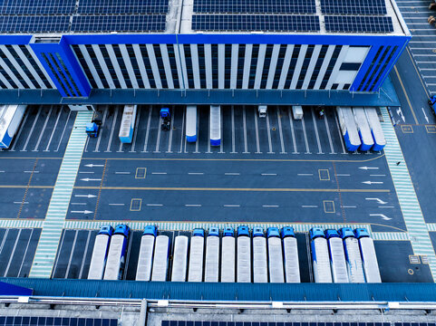 Aerial View of Factory with Solar Panels and Transport Trucks