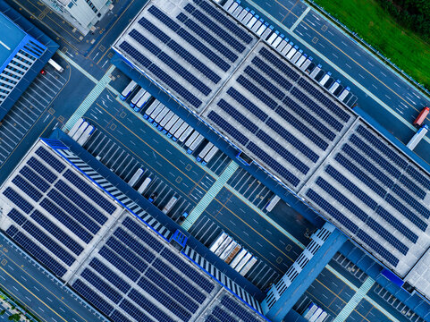Aerial View of Factory with Solar Panels and Transport Trucks