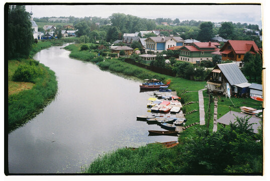 Serene river view with boats and lush greenery in a quaint town