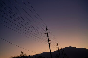 Power Lines at Dusk With Mountain Backdrop in Serene Landscape