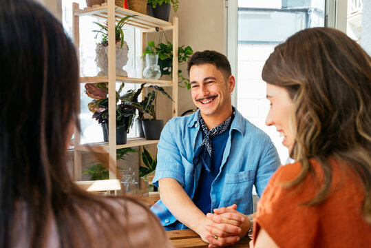 Group of friends talking at a table in a coffee shop

