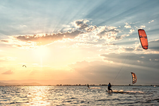 Kitesurfers silhouetted at sunset in the Ebro Delta