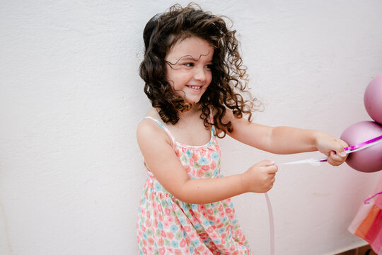 Medium shot of a young gir playing with balloons at a kids&rsquo; party