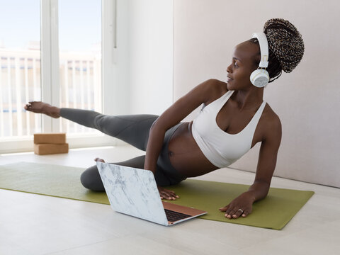 Woman Doing prenatal Exercises at Home on Mat While Watching Tutorial