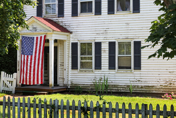 Old house with large flag draped in front of entrance