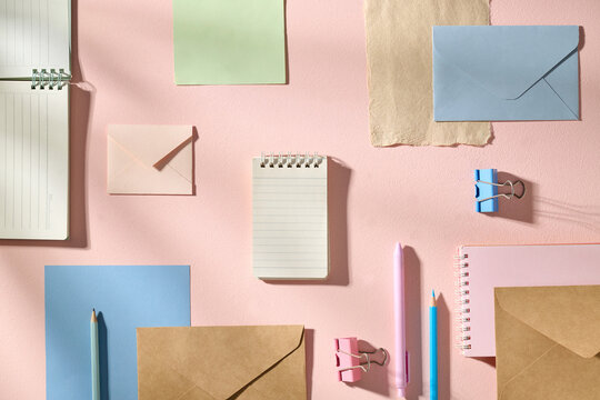 Flat Lay of Colorful Stationery Items on a Pastel Pink Background