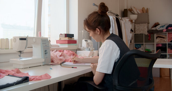 Fashion designer drawing sketches in her creative workspace