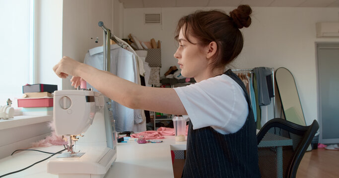 Fashion designer working on sewing machine in her atelier