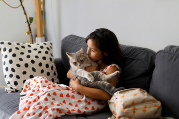 kid Cuddles a Gray Cat 