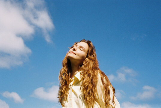 Peaceful Moment of a Woman Soaking Up the Sun with Closed Eyes 