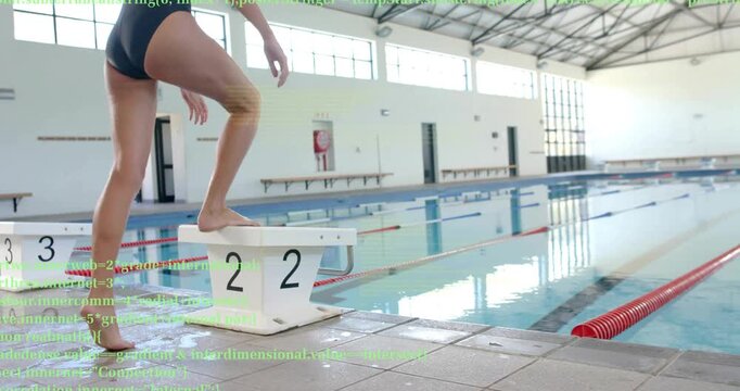 Swimmer approaching block 2 near red lanes bending knees with tech overlay preparing dive stance