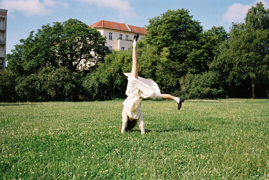 Young Woman in Cream Dress Doing a Cartwheel, analog picture
