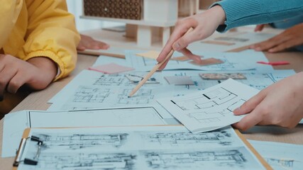 A vibrant scene showcasing diverse individuals collaborating on an architectural project. They engage with blueprints and models, highlighting creativity and teamwork in design. SACTR