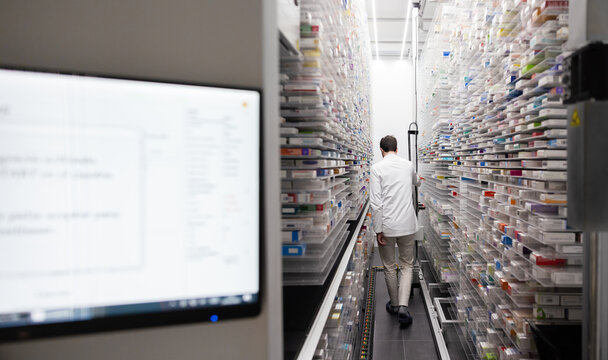 Pharmacist organizing medication in high-tech storage