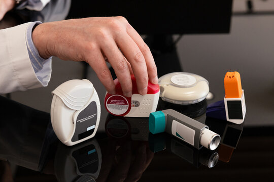 Assorted inhalers arranged on a black surface