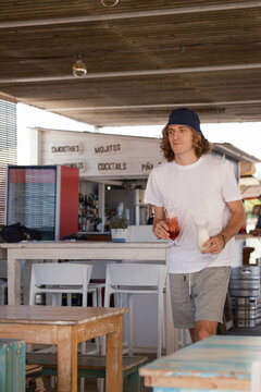 Man holding cocktails at a beach bar