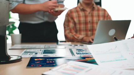 A dynamic business team collaborates on marketing strategies with charts and digital devices, fostering communication and creativity in a modern office workspace. SACTR - Powered by Adobe