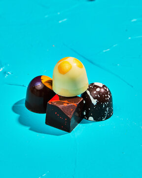 Artisan Chocolates Stacked on Bright Turquoise Backdrop