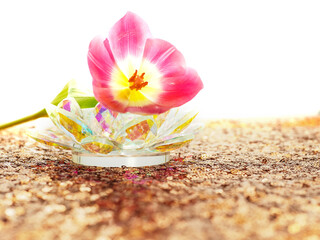 Pink tulip flowers with green stems on a gold glitter background on glass flower. The flowers are arranged in a way that they are almost touching each other. Scene is one of beauty and elegance