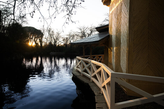 Crystal palace illuminating the retiro park lake at sunset during autumn in madrid - Powered by Adobe