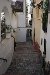Benidorm, Spain – September 8, 2025: Narrow cobbled alley with whitewashed buildings in the historic Old Town.