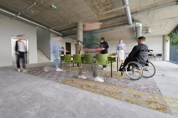 Business Team Led by Director in a Wheelchair Preparing for a Meeting in a Modern Office.