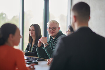 A diverse multiethnic business team engages in a collaborative meeting, discussing strategies and solutions in a modern office setting