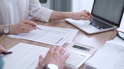 Professional female bookkeeper or auditor are working on business finances with a colleague, using calculator and laptop. Finance audit and taxes