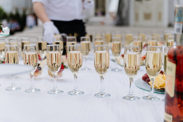 Glasses of champagne arranged on a wedding reception table outdoors