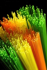 Vibrant strands of fibers in shades of orange, yellow, and green create an abstract visual effect, ideal for technology, digital art, or nature-themed projects, conveying energy and creativity,