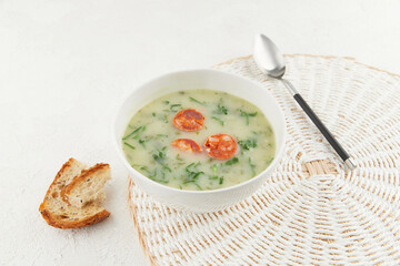 Bowl of Portuguese style soup Caldo Verde with bread on white background