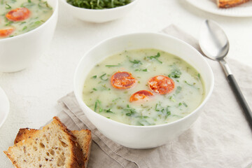 Two bowls of Portuguese style soup Caldo Verde with bread on white background
