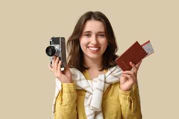 Female traveler with photo camera and passport on beige background. Itinerary concept