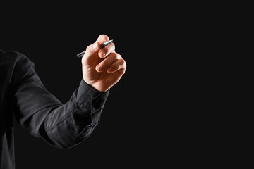 Businessman writing on black background, closeup. Goal concept