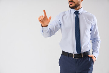 Businessman using virtual screen on light background. Goal concept