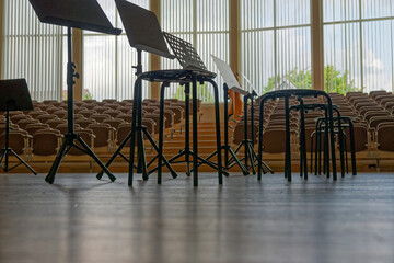 Music stands and backless stools arranged on a stage