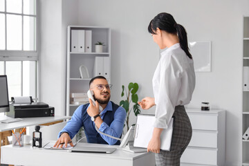 Obraz premium Young secretary and her boss working in office