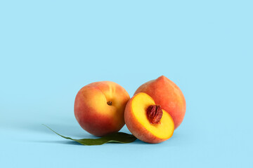 Sweet ripe peaches on blue background