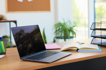 Home workspace. Modern laptop and stationery on wooden desk indoors