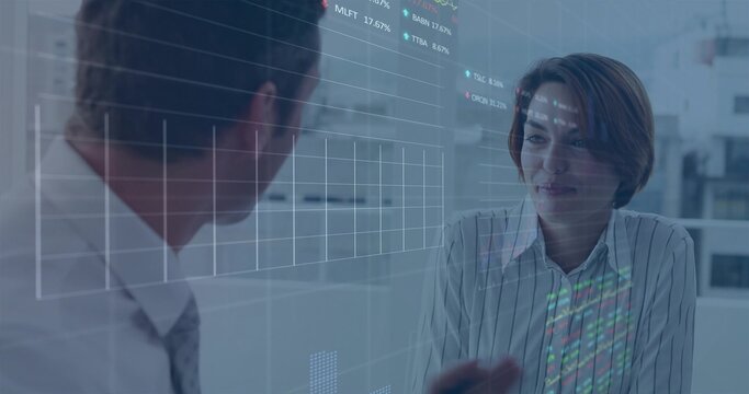 Discussing finance data, two analysts examining transparent financial charts at office glass desk