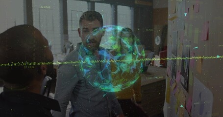 Collaborating professionals studying sticky notes wall in meeting room, with digital globe hologram