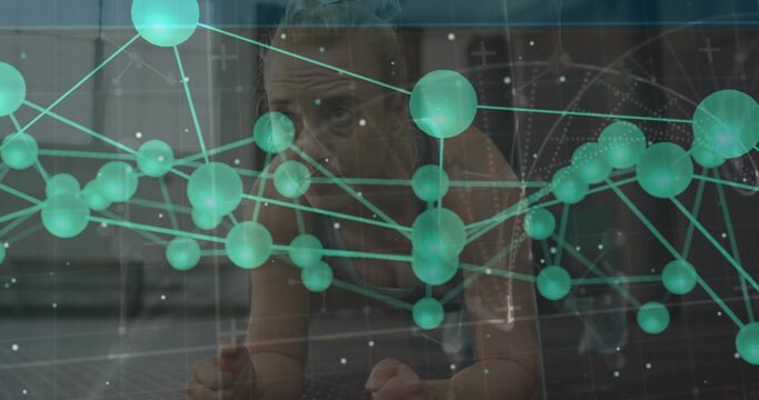 Fototapeta Holding forearm plank trainer in sportswear on exercise mat in studio with green network overlay