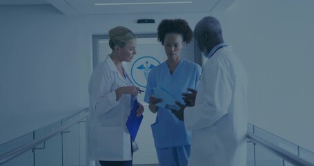 Reviewing patient charts medical team in lab coats and scrubs in hospital corridor, with clipboards