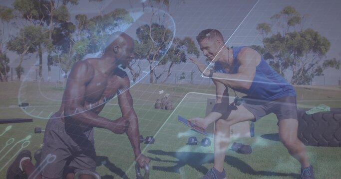 Fototapeta Kneeling and crouching partners gripping kettlebell and showing data on tablet in park