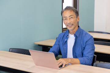 ノートパソコンを使うシニア男性