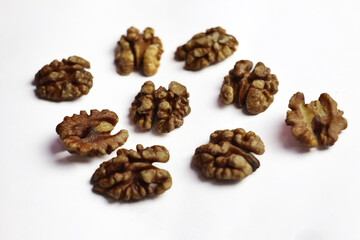 close-up of several shelled walnuts artistically scattered on a white background