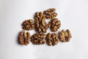 close-up of several shelled walnuts artistically scattered on a white background
