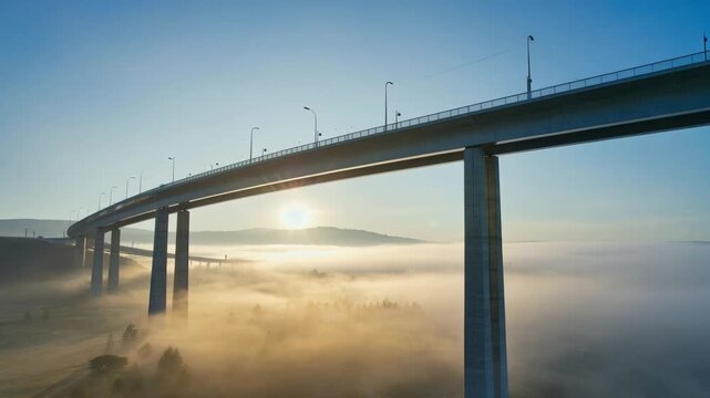 Hochbr&uuml;cke im Morgennebel mit Sonnenaufgang